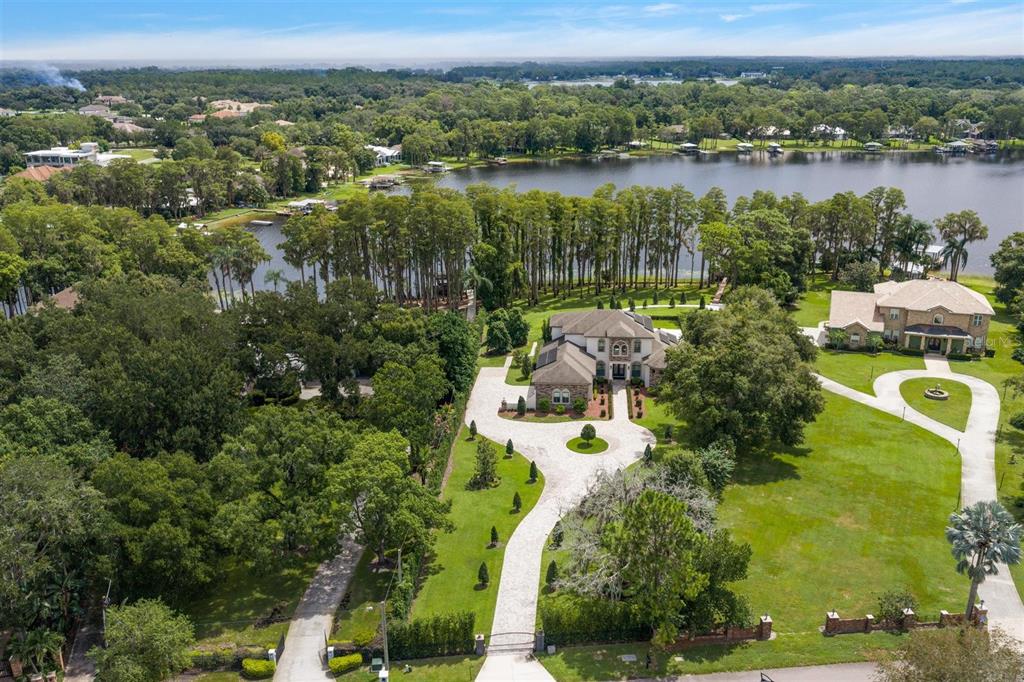 An aerial view shows a large house with a circular driveway and a lakefront backyard — 9412 EDDINGS ROAD, ODESSA, FL