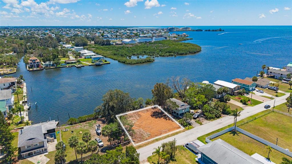 An aerial view shows a vacant, rectangular waterfront lot cleared of vegetation next to houses — 6646 SEAVIEW BOULEVARD, HUDSON, FL