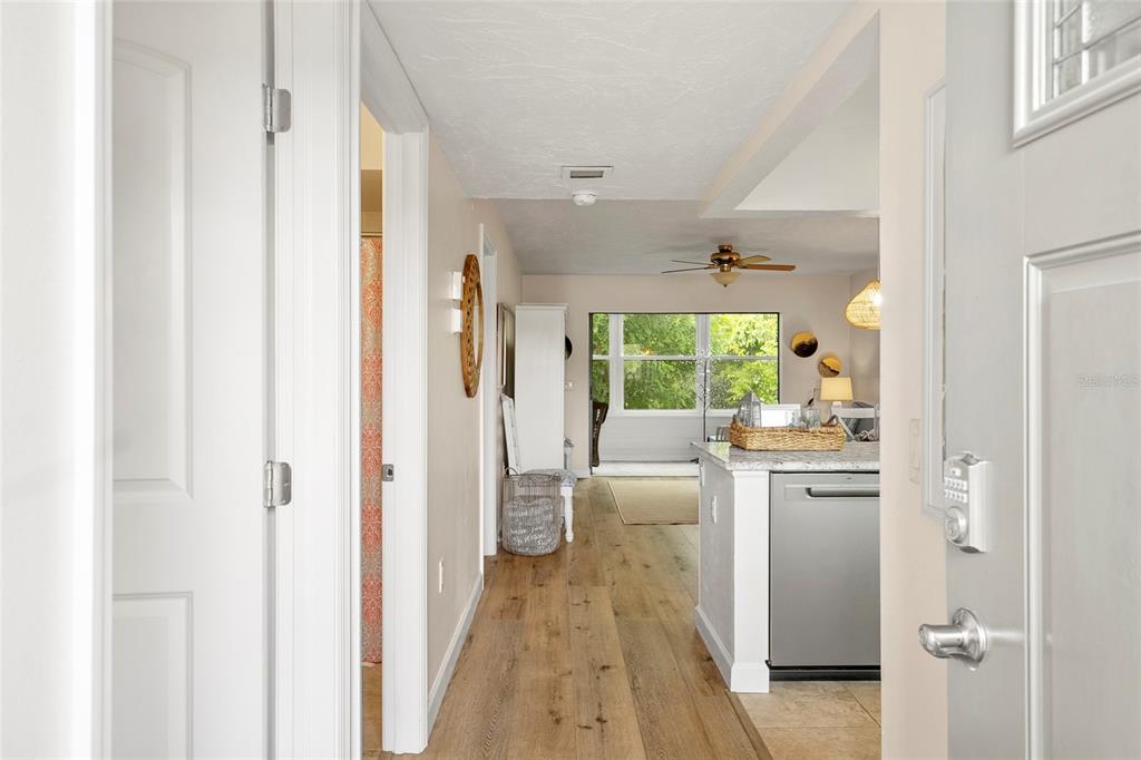 A view from an entryway looking into a kitchen and living area with wood flooring — 440 PALM TREE DRIVE UNIT N/A, BRADENTON, FL
