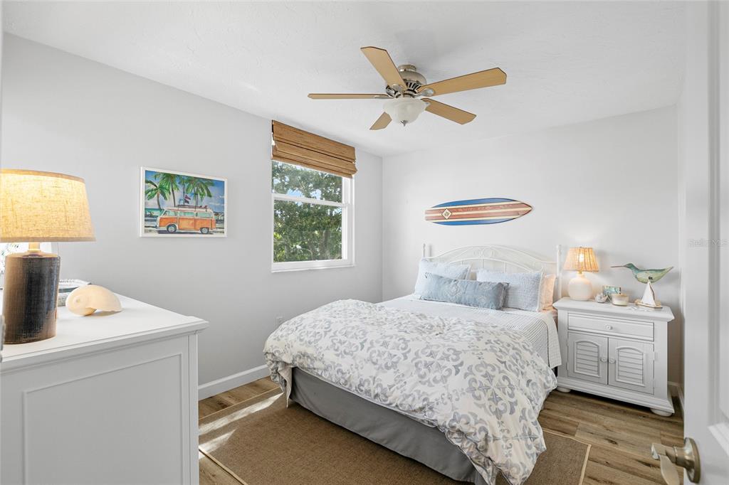 A bedroom features a bed, a ceiling fan, a window with blinds, and white furniture — 440 PALM TREE DRIVE UNIT N/A, BRADENTON, FL