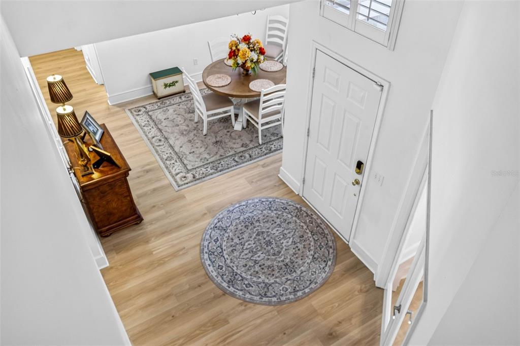 An elevated view of a foyer and dining area with light wood flooring and area rugs — 7217 RIDGEPORT DRIVE, TAMPA, FL