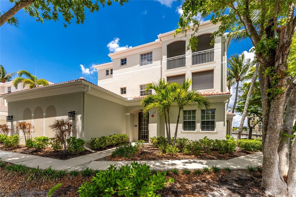 A three-story beige stucco building with a tiled roof and a front entrance walkway — 3485 SUNSET KEY CIRCLE UNIT 101, PUNTA GORDA, FL