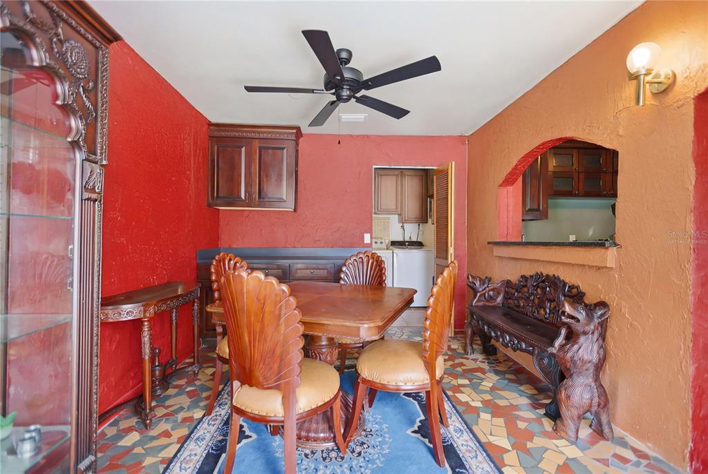 A dining room features red and orange walls, a wooden table, and patterned tile flooring — 120 VALENCIA ROAD, ROCKLEDGE, FL