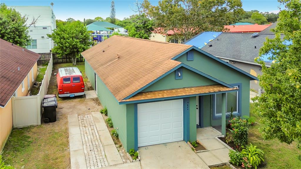 An aerial view of a green house with a brown roof and a red van — 9684 HOLLYHILL DRIVE, ORLANDO, FL