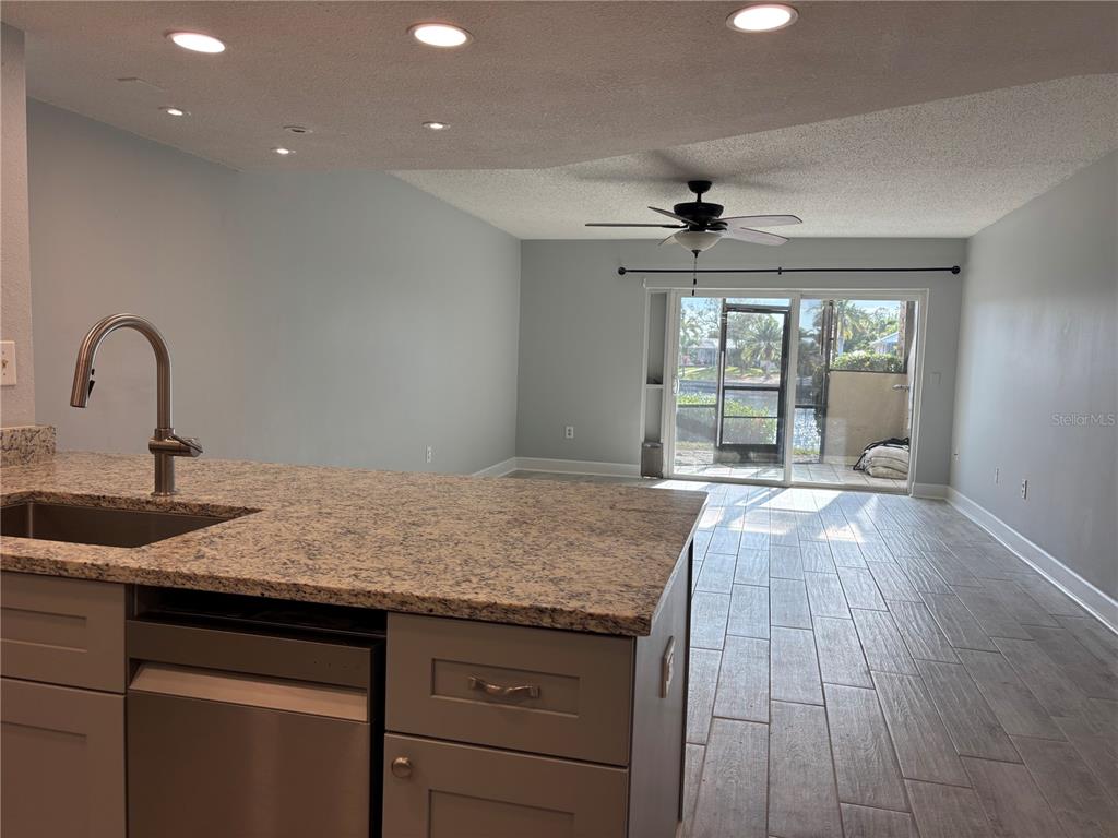A patio with lounge chairs overlooks a canal with a private dock and moored boats — 1028 APOLLO BEACH BOULEVARD UNIT 11, APOLLO BEACH, FL