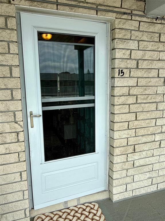 An open front door reveals a hallway with wood-look flooring and a white area rug — 5357 81ST STREET N UNIT 15, ST PETERSBURG, FL