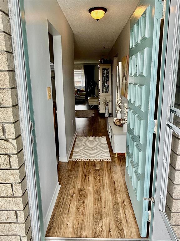 A view from a hallway looking into a living and dining area with wood flooring — 5357 81ST STREET N UNIT 15, ST PETERSBURG, FL