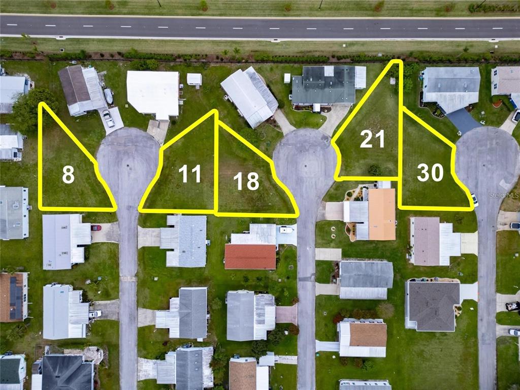 This aerial map shows several vacant residential lots highlighted in yellow within a neighborhood — LOT 11 BLK D LEXINGTON CIRCLE, WILDWOOD, FL