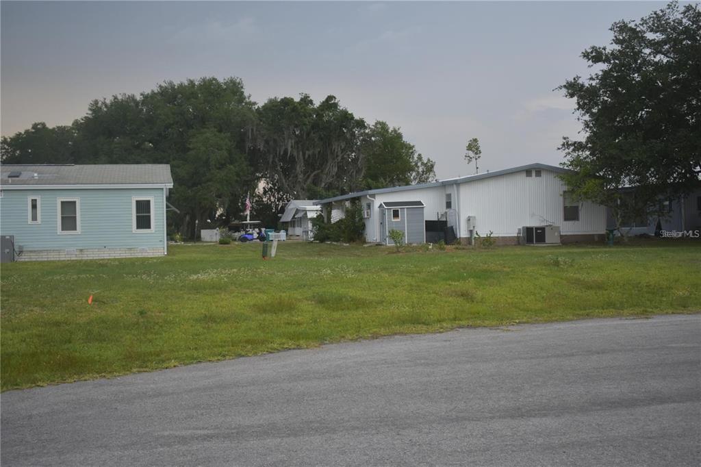 A view of two mobile homes with a grassy yard and a small shed — LOT 11 BLK D LEXINGTON CIRCLE, WILDWOOD, FL