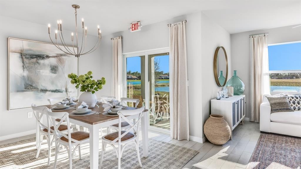 A dining area with a wooden table, white chairs, and a view of a lake — 1445 MABLETON DRIVE, PORT CHARLOTTE, FL