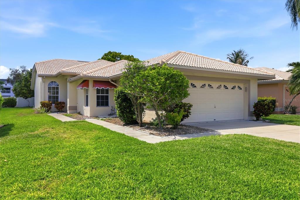 A front entryway features a white door, a large arched window, and potted plants — 4738 DUNDEE DRIVE, BRADENTON, FL