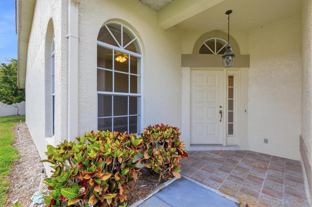 A kitchen with light wood cabinets, a white island, stainless steel appliances, and green tile floors — 4738 DUNDEE DRIVE, BRADENTON, FL