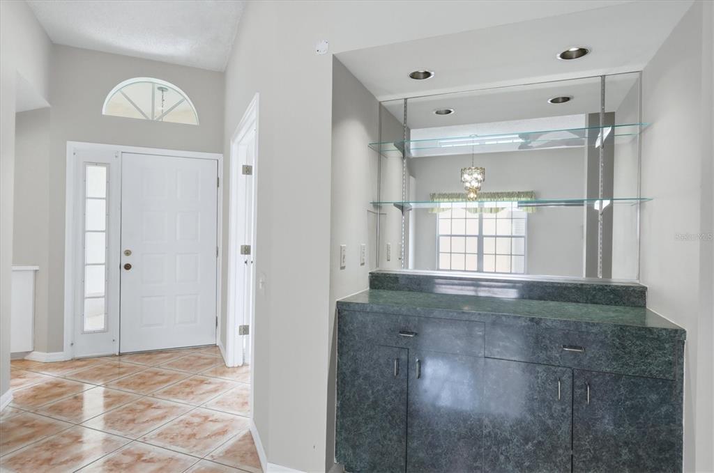 A kitchen features light wood cabinets, stainless steel appliances, white countertops, and a blue backsplash — 4738 DUNDEE DRIVE, BRADENTON, FL