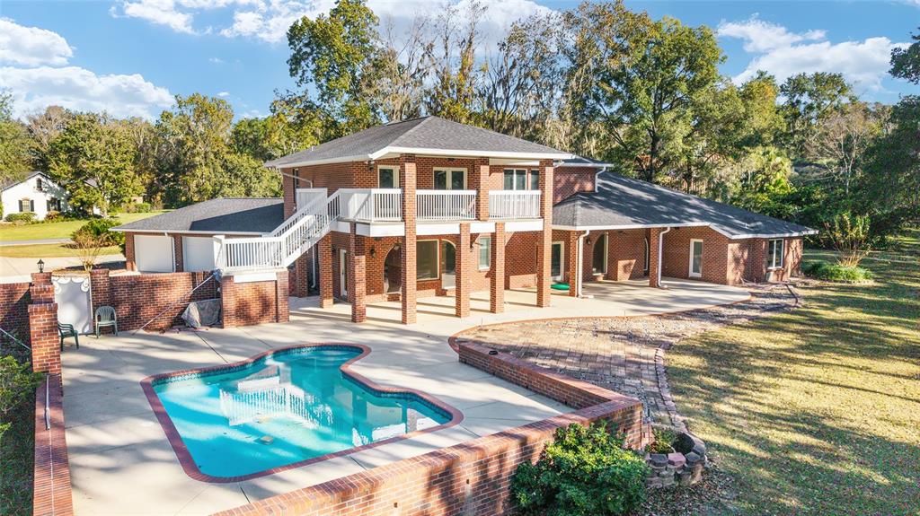 A two-story brick house with a swimming pool, patio, and an elevated wooden deck — 1570 SE 73RD PLACE, OCALA, FL