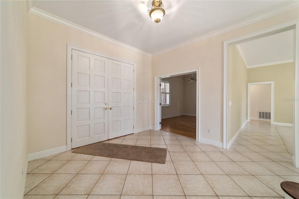 An entryway with tile flooring, a double-door entrance, and doorways leading to other rooms — 1570 SE 73RD PLACE, OCALA, FL