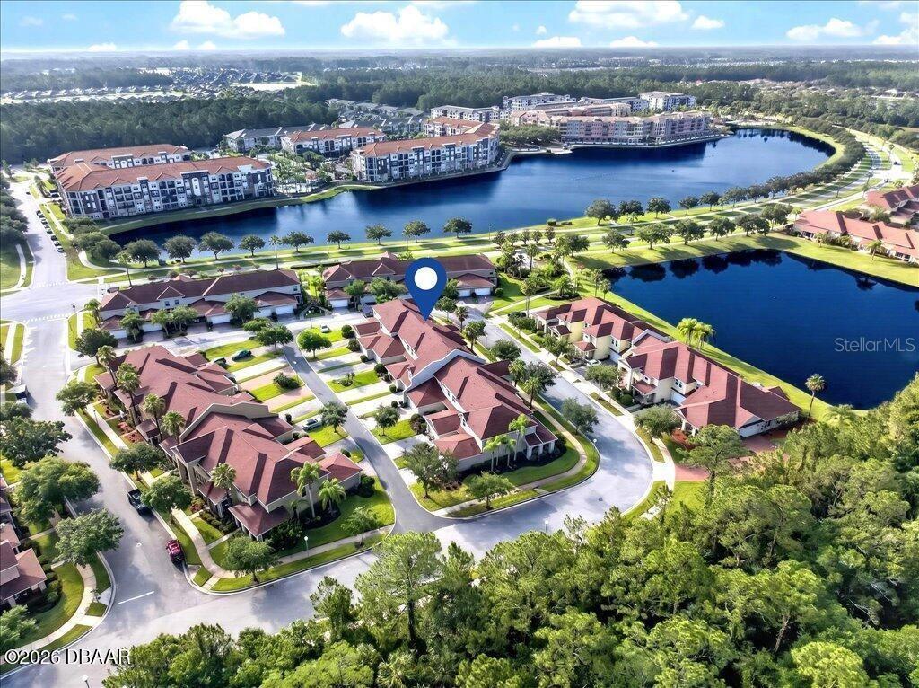 An aerial view shows a residential complex with multiple buildings, a lake, and surrounding trees — 3616 TRESTO STREET, NEW SMYRNA BEACH, FL