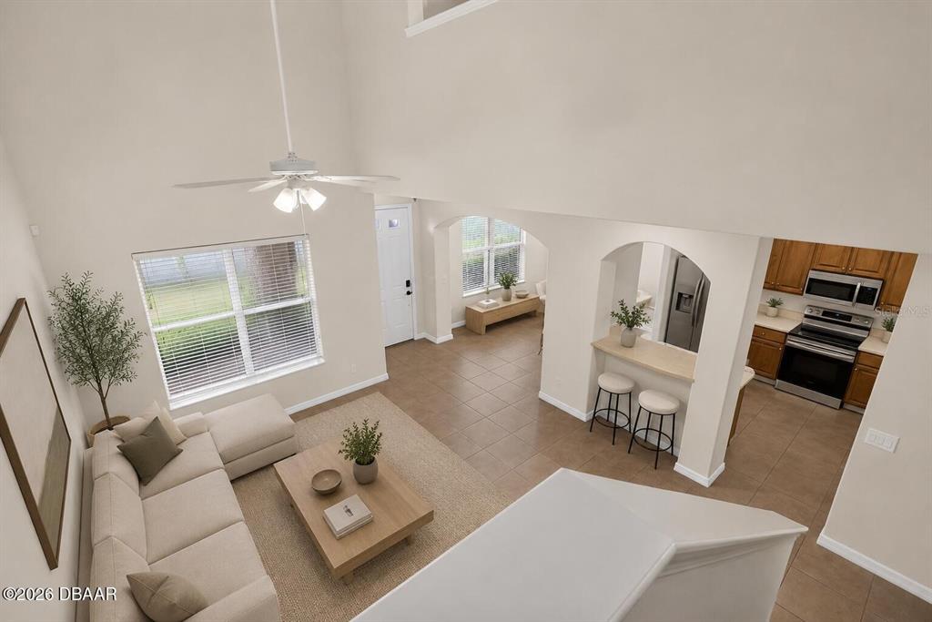 An elevated view shows a living room with a vaulted ceiling, tile floors, and kitchen — 3616 TRESTO STREET, NEW SMYRNA BEACH, FL