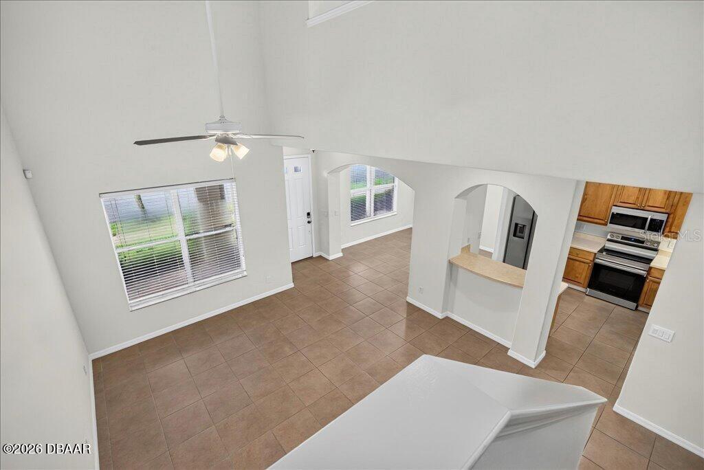 An elevated view shows a living area with tile floors, a ceiling fan, and an adjacent kitchen — 3616 TRESTO STREET, NEW SMYRNA BEACH, FL