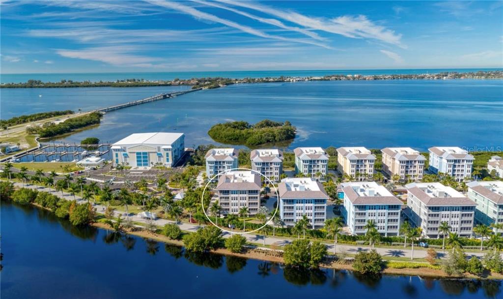 An aerial view shows a multi-story residential building circled among others near a coastal waterway — 395 ARUBA CIRCLE UNIT 203, BRADENTON, FL
