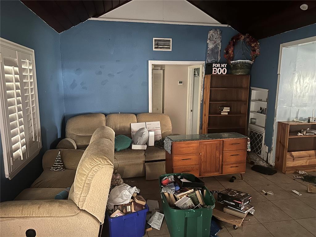 A living room with blue walls, a beige sectional sofa, and various storage bins — 1245 35TH AVENUE, VERO BEACH, FL