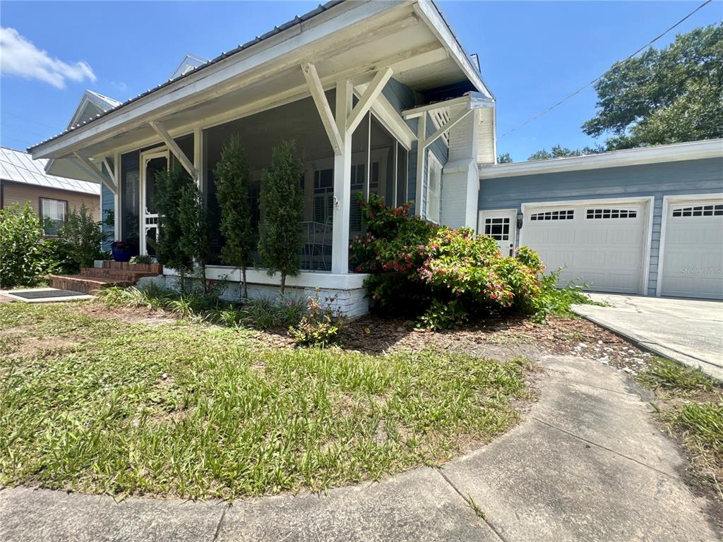 A blue house with a screened-in front porch and an attached two-car garage — 1102 N ARCADIA AVENUE, ARCADIA, FL
