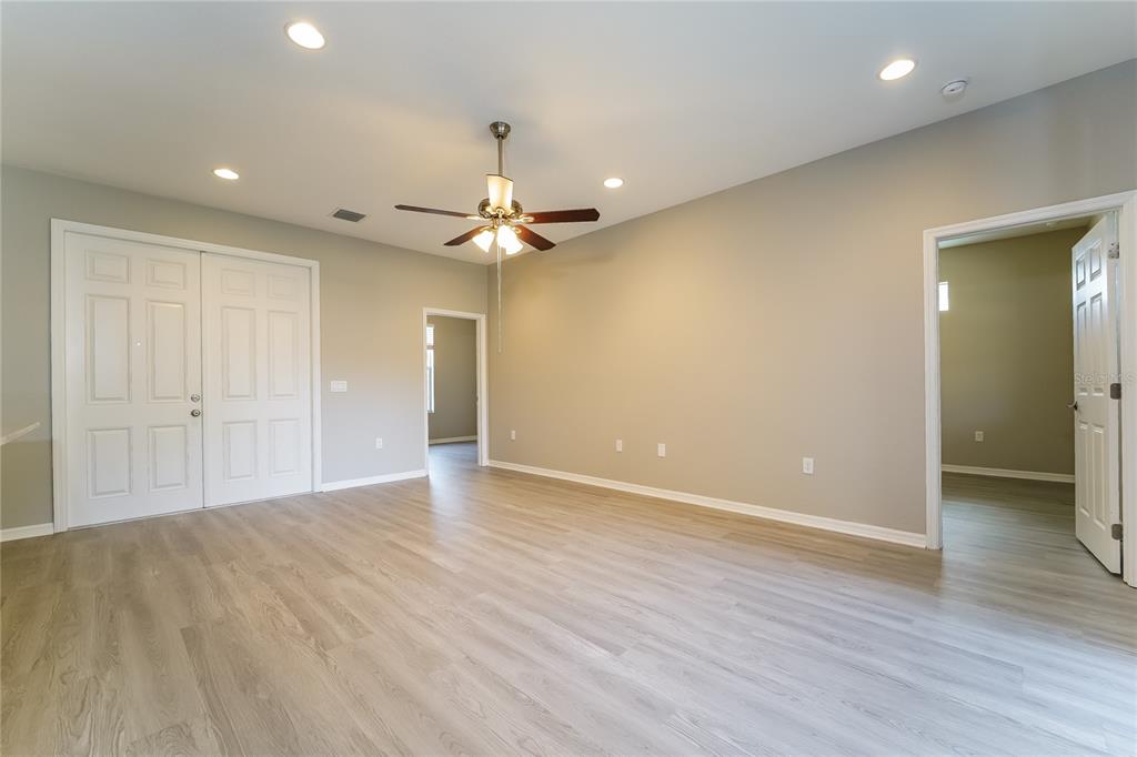An empty room with light wood-look flooring, a ceiling fan, and two doorways — 4311 ABCOR ROAD, NORTH PORT, FL