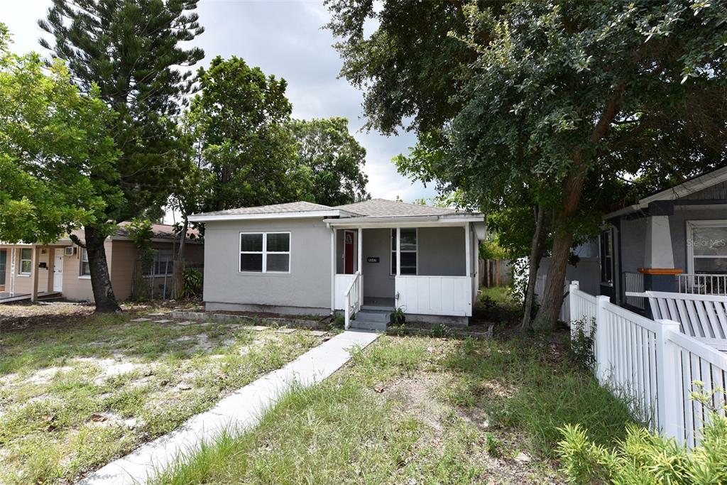 A single-story house with a gray exterior, a front porch, and a concrete walkway — 4642 10TH AVENUE S, ST PETERSBURG, FL