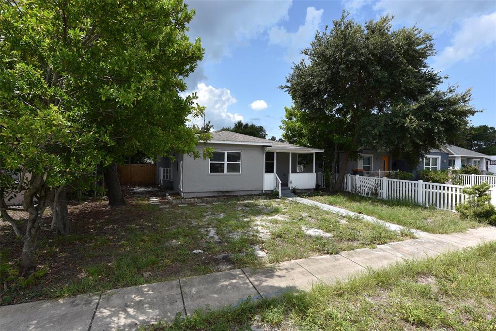 A gray single-story house with a front porch and a white picket fence — 4642 10TH AVENUE S, ST PETERSBURG, FL