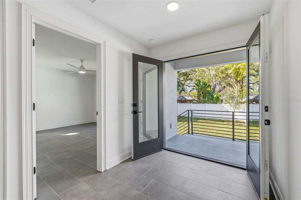A tiled entryway leads to a bedroom and an open door onto a railed balcony — 4509 W NORTH A STREET UNIT 2, TAMPA, FL