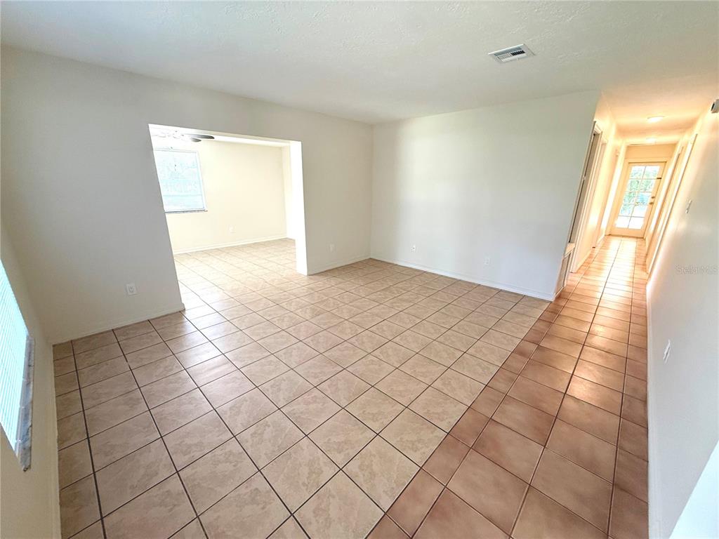 An empty room features light-colored tile flooring, white walls, and a white front door — 101 S FLAMINGO AVENUE, WINTER SPRINGS, FL