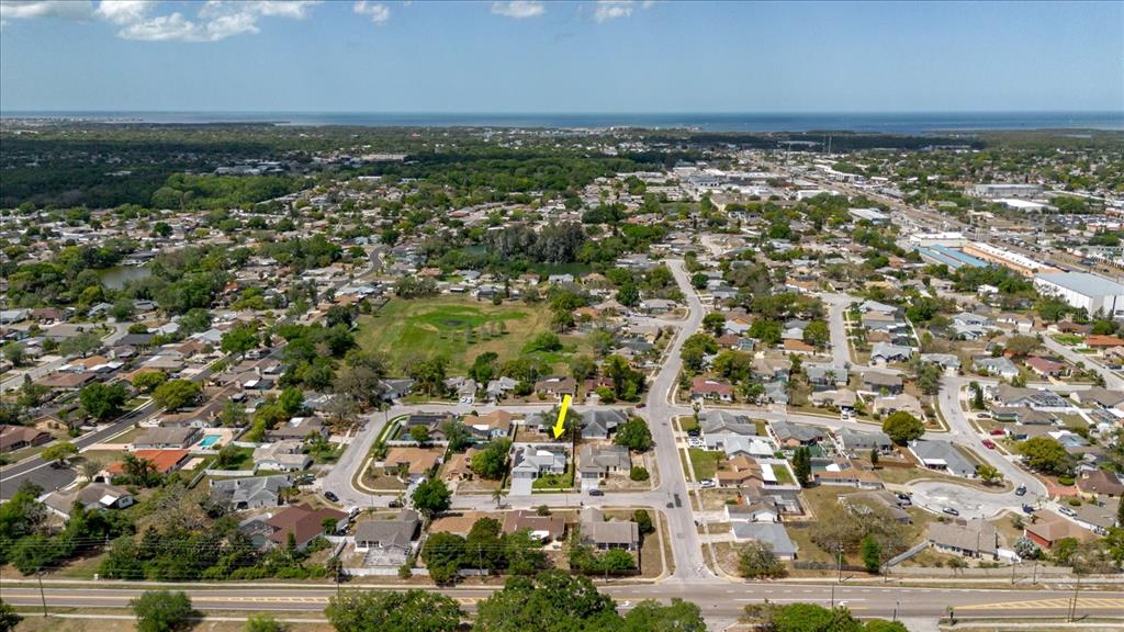 An aerial view shows a residential neighborhood with a yellow arrow pointing to a house — 8112 GOLDEN BEAR LOOP, PORT RICHEY, FL