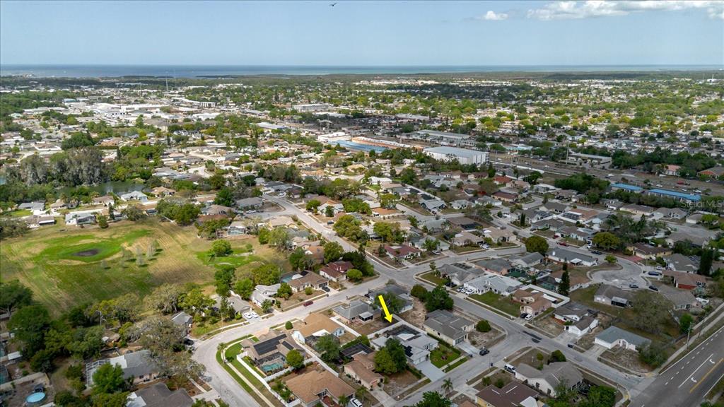 An aerial view shows a suburban neighborhood with a yellow arrow pointing to a house — 8112 GOLDEN BEAR LOOP, PORT RICHEY, FL