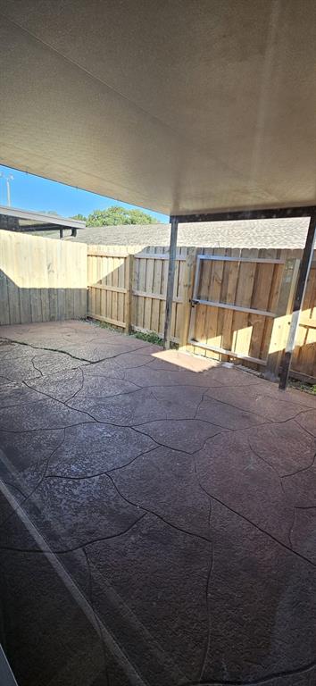 A covered patio with stamped concrete flooring and a wooden privacy fence — 2227 MARGARITA COURT UNIT 2227, KISSIMMEE, FL
