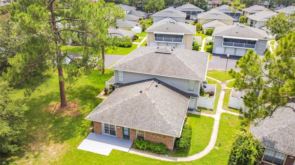 An aerial view shows a two-story residential building with a gray roof and brick facade — 4375 SHADOW CREST PLACE UNIT 34-1, ORLANDO, FL