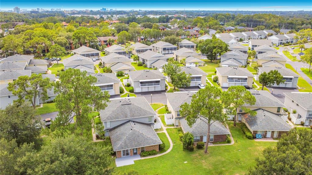 An aerial view of a residential community featuring multiple townhouses surrounded by green lawns — 4375 SHADOW CREST PLACE UNIT 34-1, ORLANDO, FL