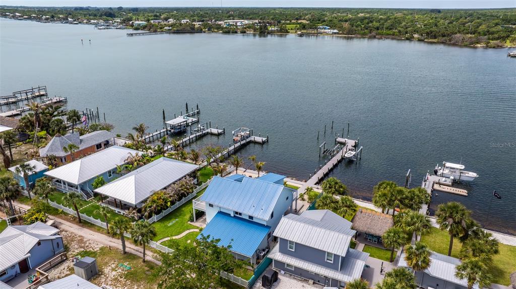 An aerial view shows several waterfront houses with metal roofs and private docks — 17 VIP A ISLAND, GRANT, FL