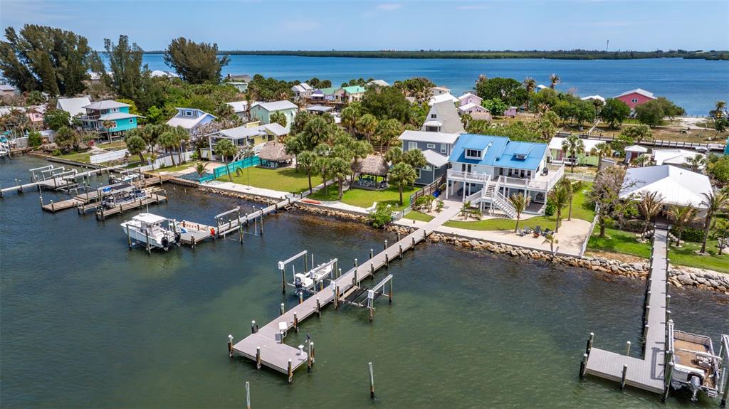 An aerial view shows waterfront homes with private docks and boats along a coastal inlet — 17 VIP A ISLAND, GRANT, FL