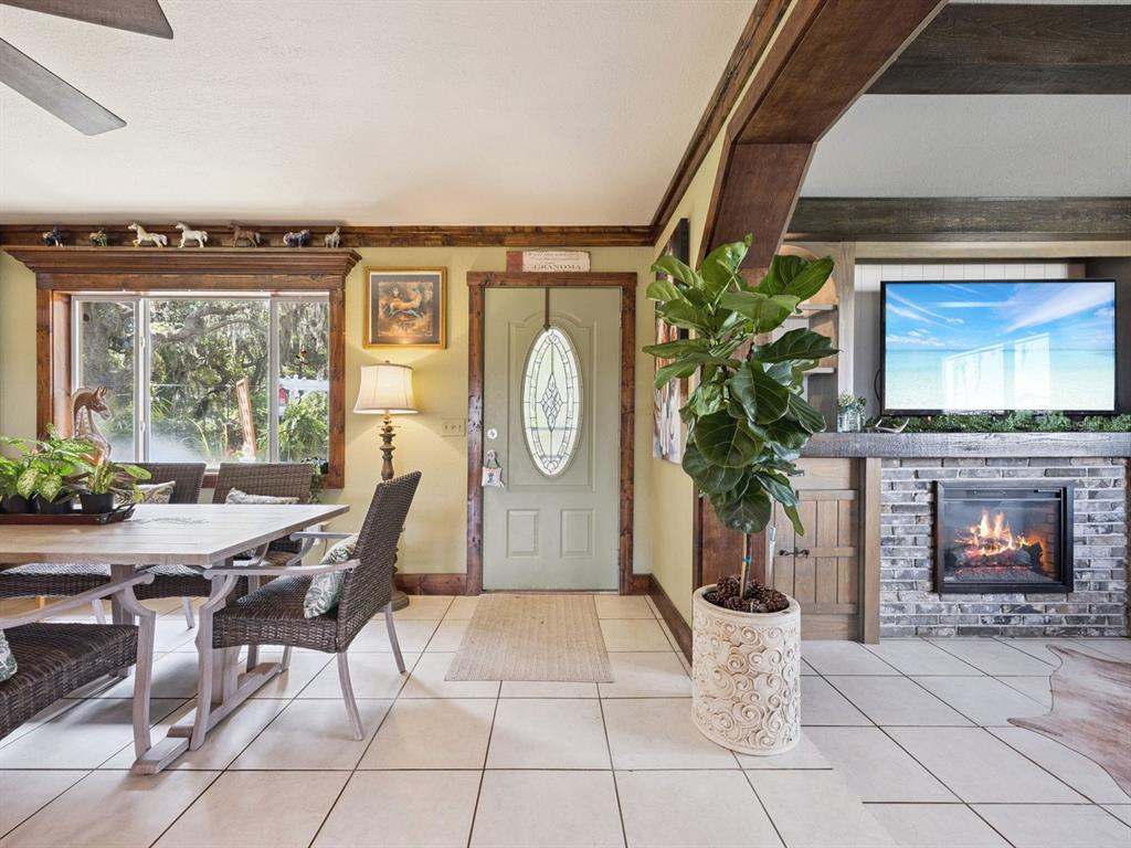 A dining area and entryway feature tile floors, a fireplace, and a large potted plant — 6001 MARTHAS LANE, ST CLOUD, FL
