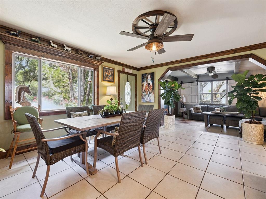 A dining room with a wagon wheel ceiling fan, wicker chairs, and tile flooring — 6001 MARTHAS LANE, ST CLOUD, FL