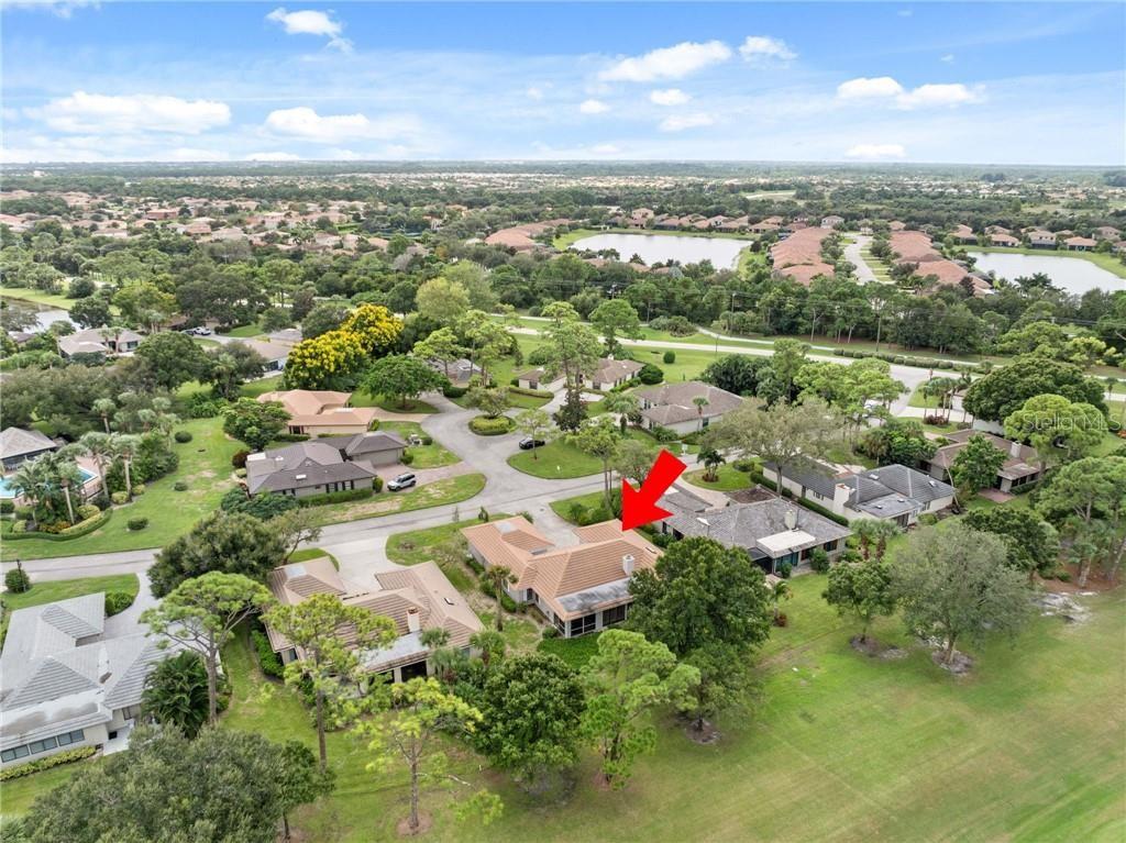 An aerial view shows a residential house with a tiled roof and pool enclosure — 110 PRESTWICK CIRCLE, VERO BEACH, FL