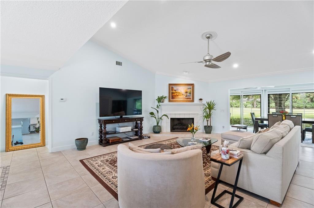 A living room features a fireplace, a television on a console, and a large sectional — 110 PRESTWICK CIRCLE, VERO BEACH, FL