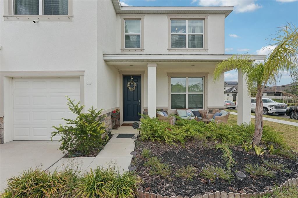 A two-story house exterior features a white stucco facade, a garage, and a front porch — 13055 WILLOW GROVE DRIVE, RIVERVIEW, FL
