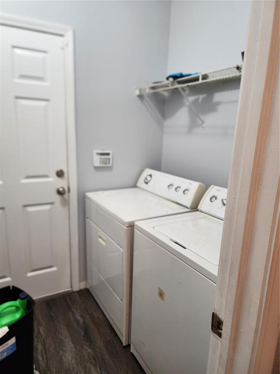 A laundry room features a white washer and dryer, a wire shelf, and a door — 1701 CHALKSAND WAY, RUSKIN, FL