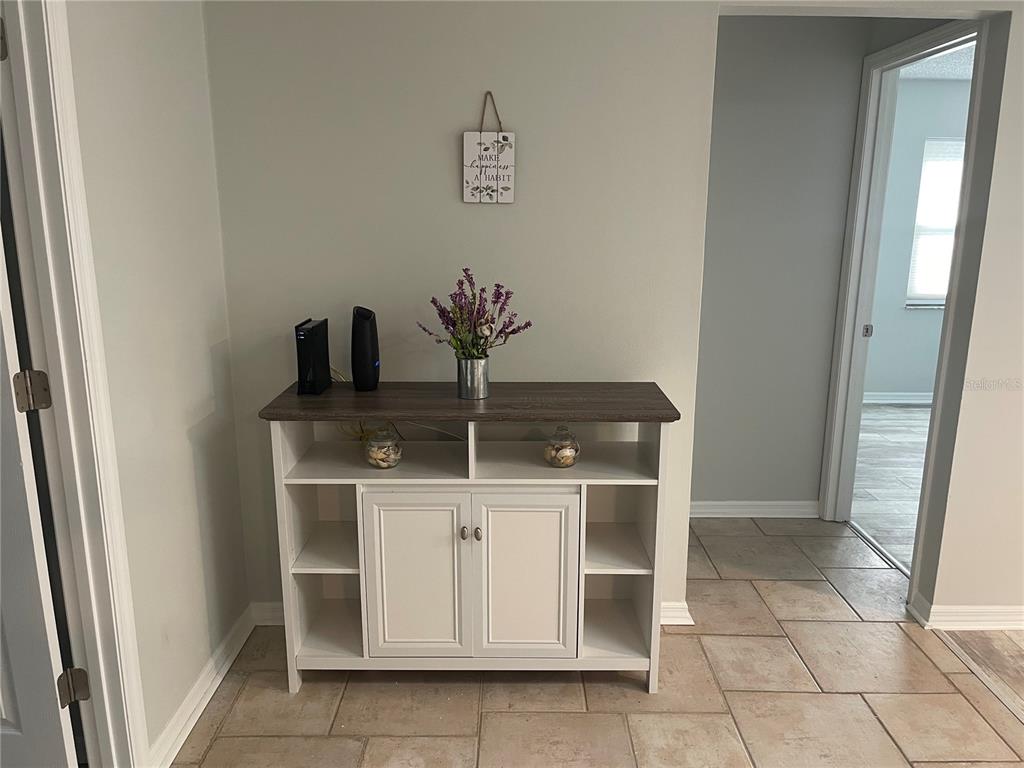A white cabinet with a dark wood top sits against a wall in a tiled room — 21 POST VIEW DRIVE, PALM COAST, FL