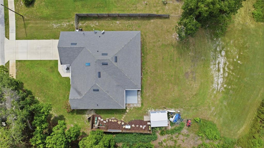 An aerial view shows a house with a gray roof, a driveway, and a backyard — 120 FLORIDANA ROAD, DEBARY, FL