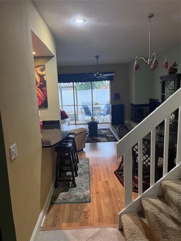 An interior view shows a kitchen breakfast bar, dining area, and living space with stairs — 3047 OVERLOOK PLACE, CLEARWATER, FL
