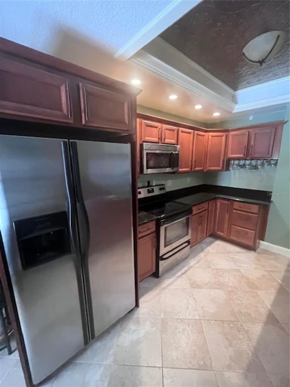 A kitchen features stainless steel appliances, dark wood cabinetry, and a decorative ceiling tray — 3047 OVERLOOK PLACE, CLEARWATER, FL