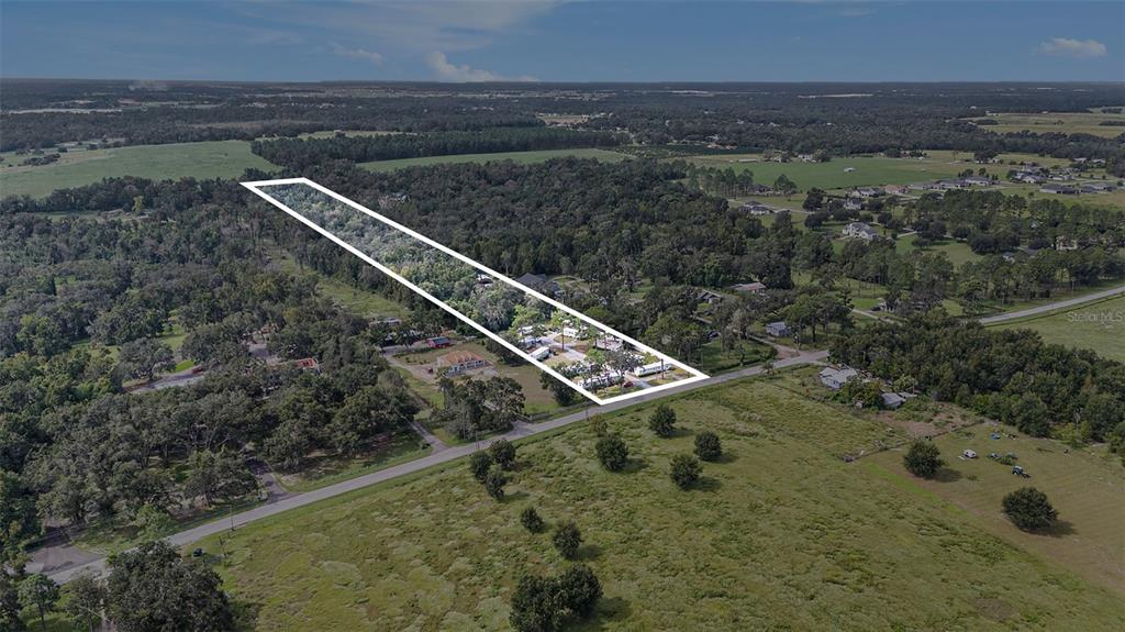 An aerial view shows a long, rectangular plot of land outlined in white — 14638 TREELEAF LANE, DADE CITY, FL