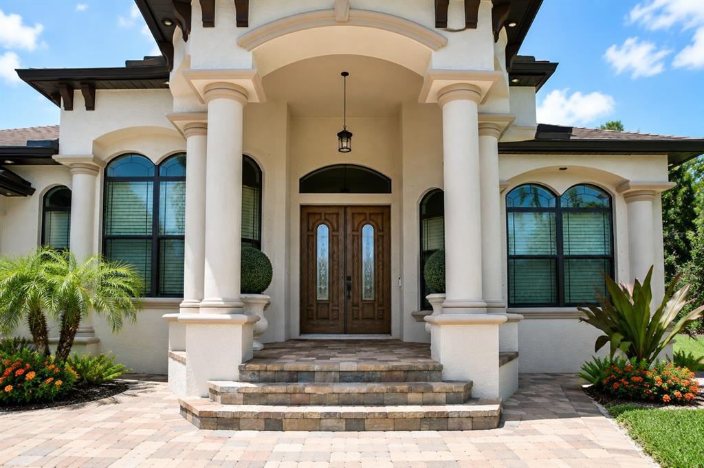 A front entrance with double wooden doors, stone steps, and two large white columns — 2197 NITA TERRACE, NORTH PORT, FL