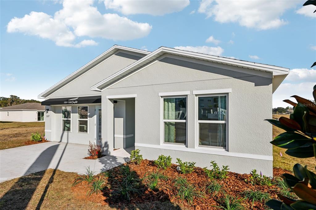 A light gray single-story house exterior features a covered entryway and a landscaped front yard — 2047 WALSH AVENUE SE, PALM BAY, FL